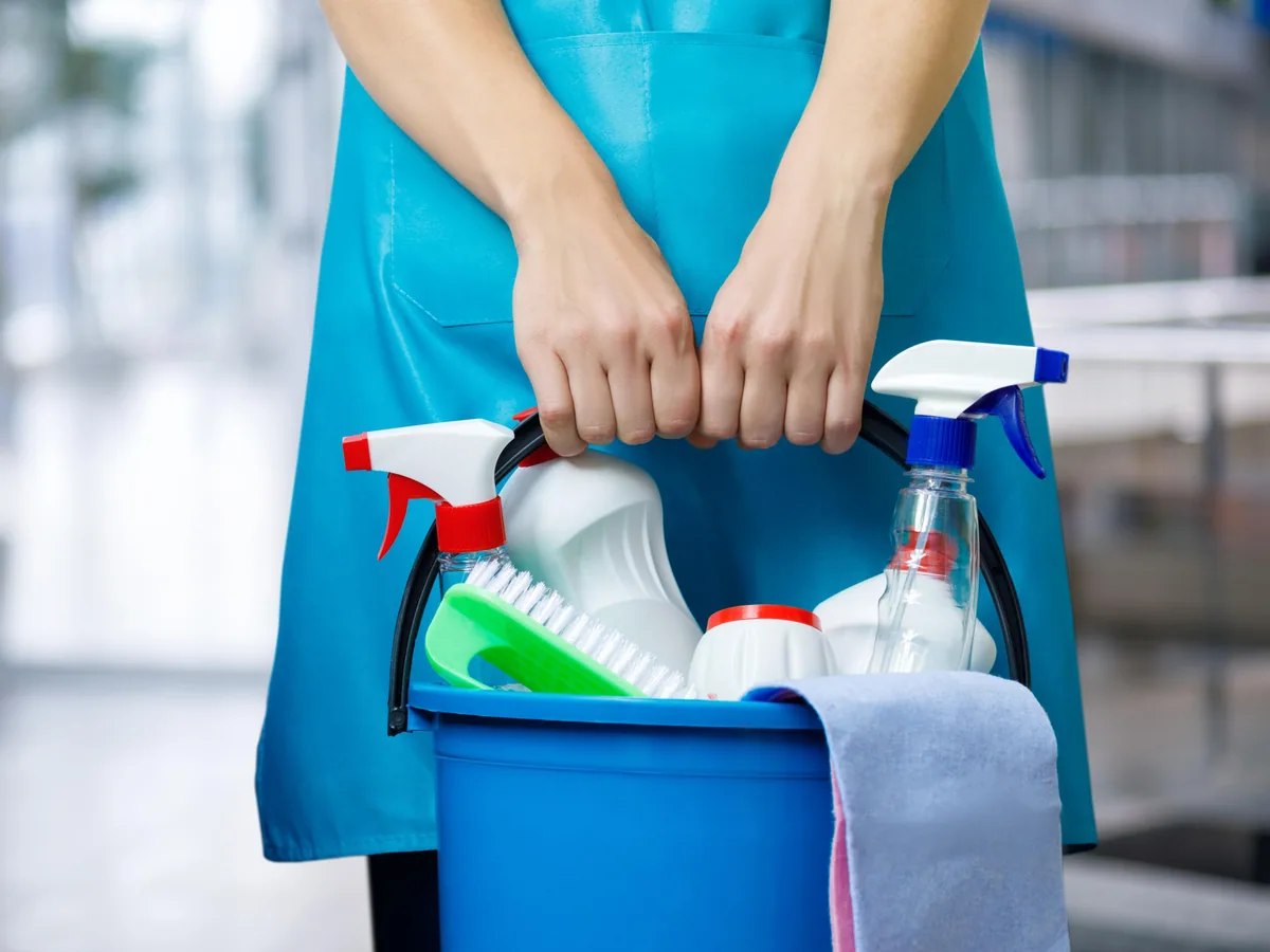 Professional cleaner prepared with supplies for residential cleaning service